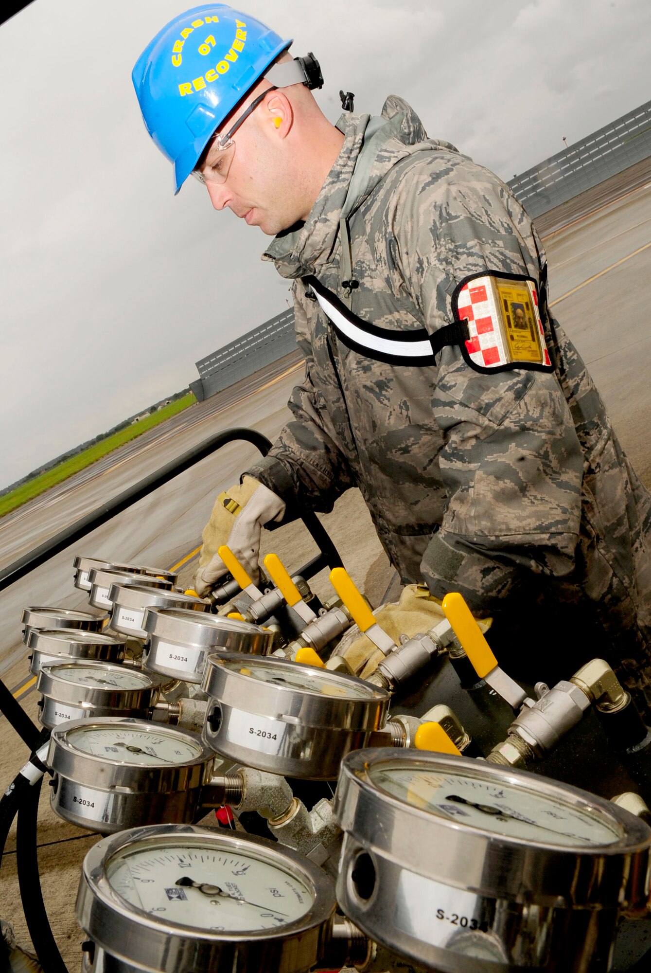 RAF MILDENHALL, England – Staff. Sgt. William Musgrove, 100th Maintenance Squadron repair and reclamation craftsman, monitors the amount of air being released into lifting bags during a crash recovery exercise on the flightline at RAF Mildenhall July 20, 2012. A manifold is used to control the amount of air released into the lifting bags along with measuring the PSI in each bag. (U.S. Air Force photo/Senior Airman Ethan Morgan)