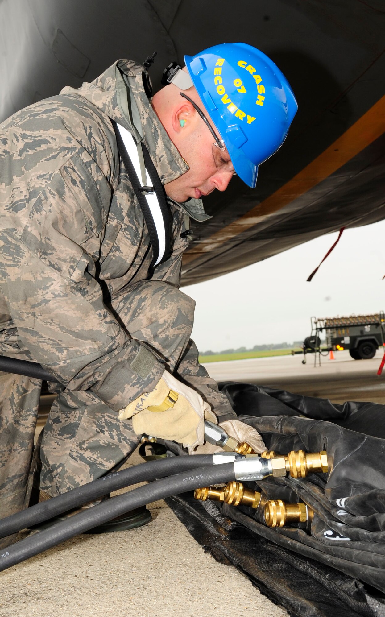RAF MILDENHALL, England – Staff. Sgt. William Musgrove, 100th Maintenance Squadron repair and reclamation craftsman, attaches air hoses to lifting bags during a crash recovery exercise on the RAF Mildenhall flightline July 20, 2012. The lifting bags are placed in key points around an aircraft and are used to lift and stabilize the aircraft. (U.S. Air Force photo/Senior Airman Ethan Morgan)
