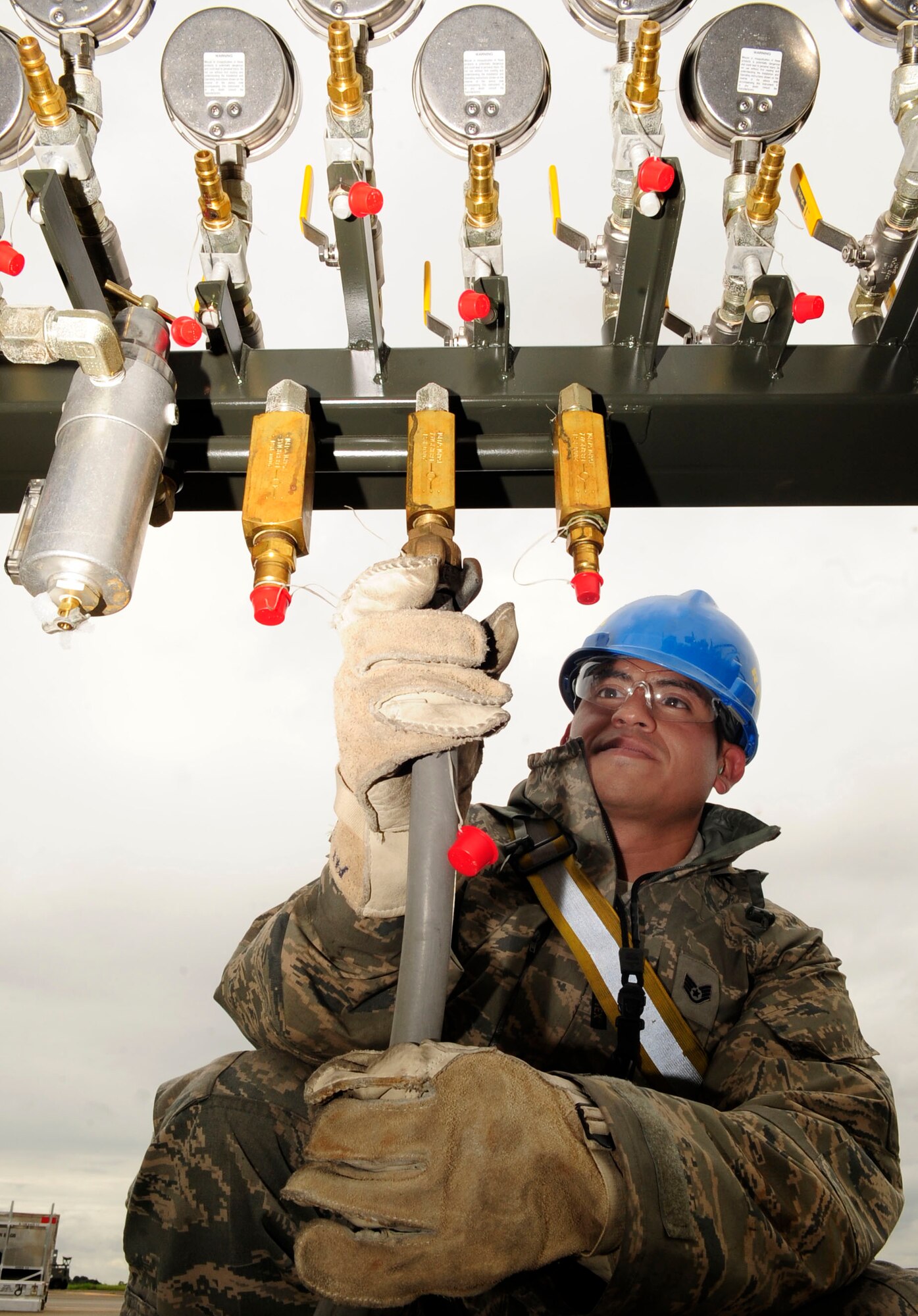 RAF MILDENHALL, England – Staff. Sgt. Jose Tapia, 100th Maintenance Squadron repair and reclamation craftsman, attaches an air compressor hose to a manifold during a crash recovery exercise on the RAF Mildenhall flightline July 20, 2012. The manifold is used to control the air flow into lifting bags that are used to raise large objects. (U.S. Air Force photo/Senior Airman Ethan Morgan)
