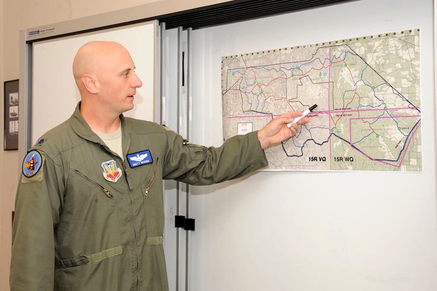 Lt. Col. Brett Waring 548th Combat Training Squadron Det 1 director of operations points out one of the maps used by visiting units during a Green Flag East exercise on Barksdale Air Force Base, La., July 18. The 548th CTS facilities has are used by visiting squadrons for a place to plan missions, brief pilots and launch aircraft. (U.S. Air Force Photo/Airman 1st Class Andrew Moua)(RELEASED) 