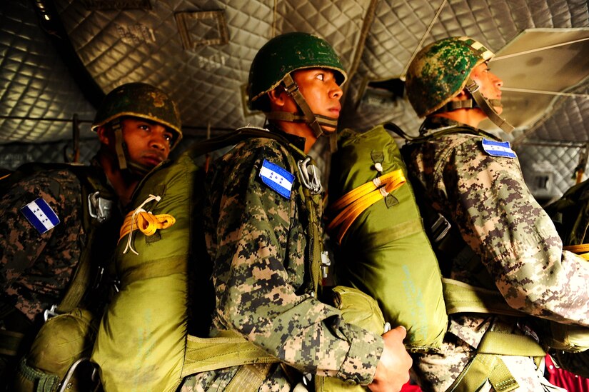 SOTO CANO AB, Honduras – Honduran army paratroopers stand up and hold the static line in a CH-47 Chinook helicopter, listening closely to their jumpmaster’s commands during a combined airborne exercise at Joint Task Force-Bravo. (U.S. Air Force photo by 1st Lt. Christopher Diaz)