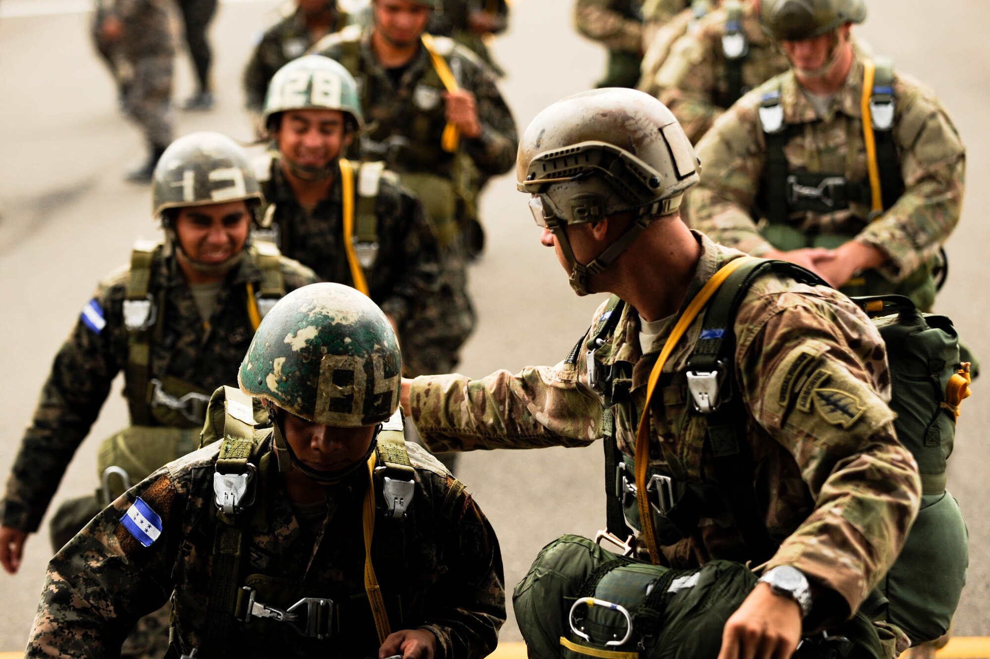 SOTO CANO AB, Honduras – A U.S. Army paratrooper guides fellow Honduran paratroopers onto a CH-47 Chinook helicopter during a combined airborne exercise at Joint Task Force-Bravo. (U.S. Air Force photo by 1st Lt. Christopher Diaz)