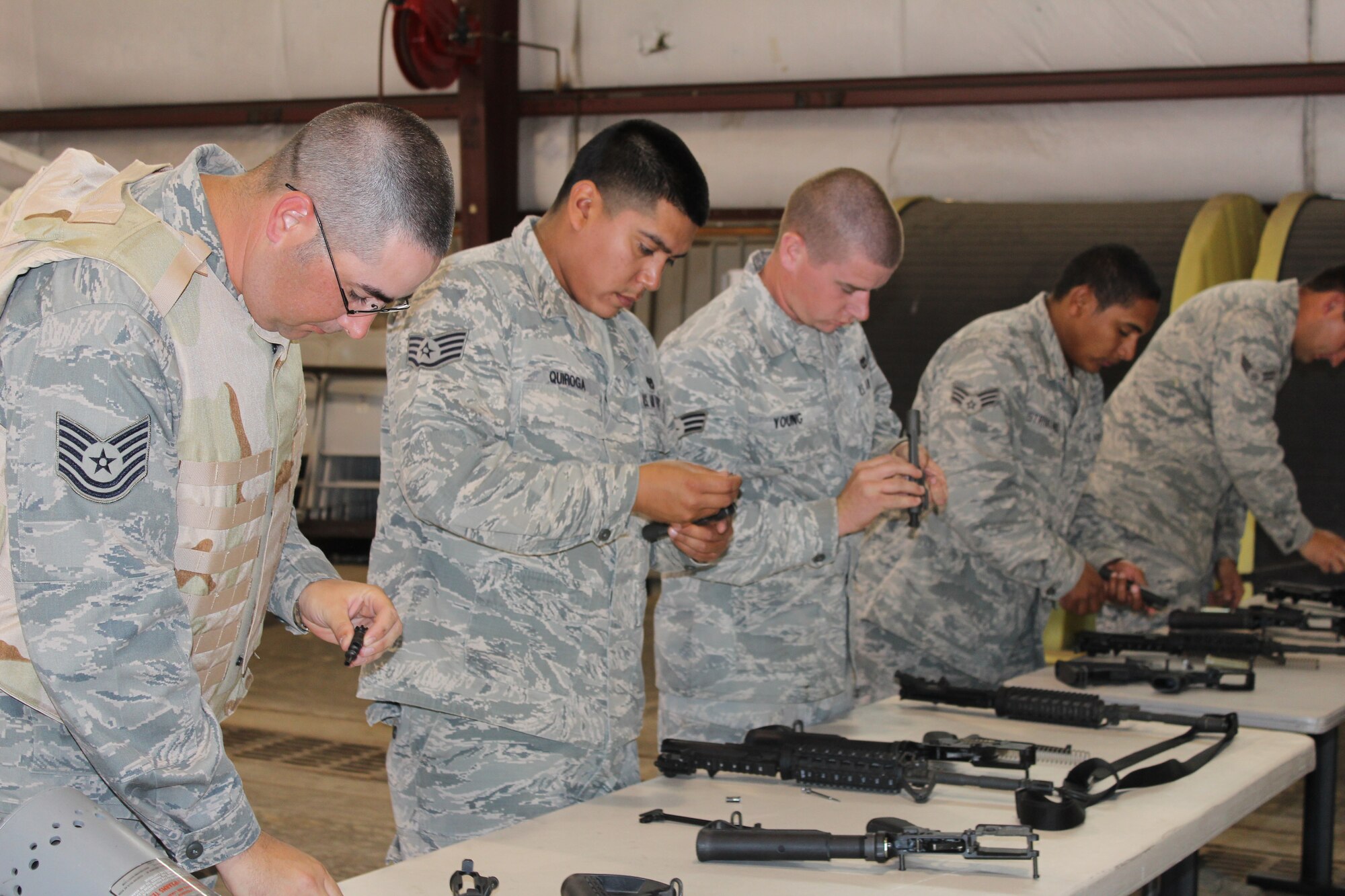 PETERSON AIR FORCE BASE, Colo. -- Following a weapons handling course June 21, 2012, Tech. Sgt. Russell Polluck (left to right), Staff Sgt. Rosario Quiroga, Senior Airman Kenneth Young and other members of the 21st Civil Engineer Squadron are evaluated on proper nomenclature and fieldstripping procedures of M4 assault rifles. The training was held June 21, 2012, and was part of the squadron’s monthly contingency training. (U.S. Air Force photo/Staff Sgt. Shakib Rahman)