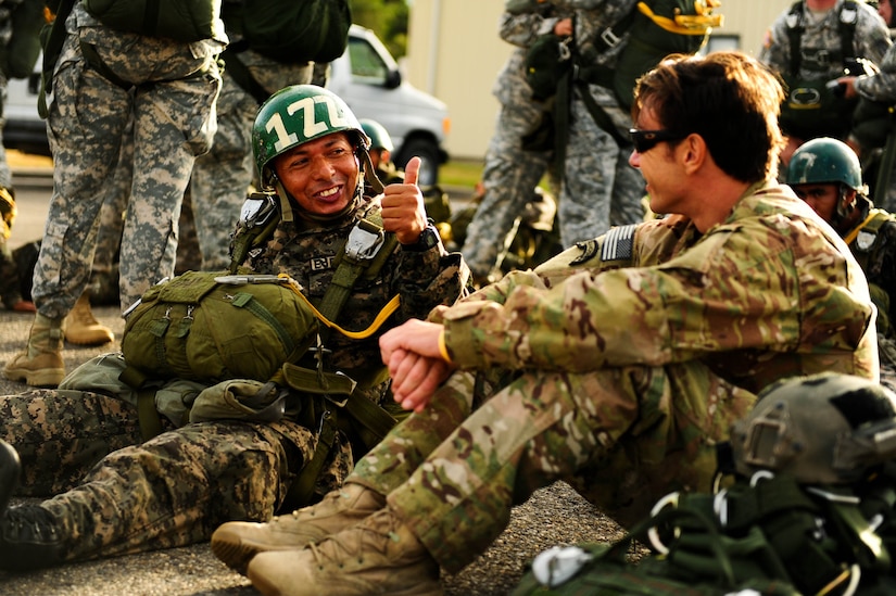 SOTO CANO AB, Honduras – A Honduran paratrooper has a friendly conversation with a U.S. Army paratrooper as they both wait to load onto a CH-47 Chinook helicopter during a combined airborne exercise at Joint Task Force-Bravo. The exercise was designed to sharpen the paratroopers’ airborne proficiency and strengthen the partnership between the two militaries. (U.S. Air Force photo by 1st Lt. Christopher Diaz)
