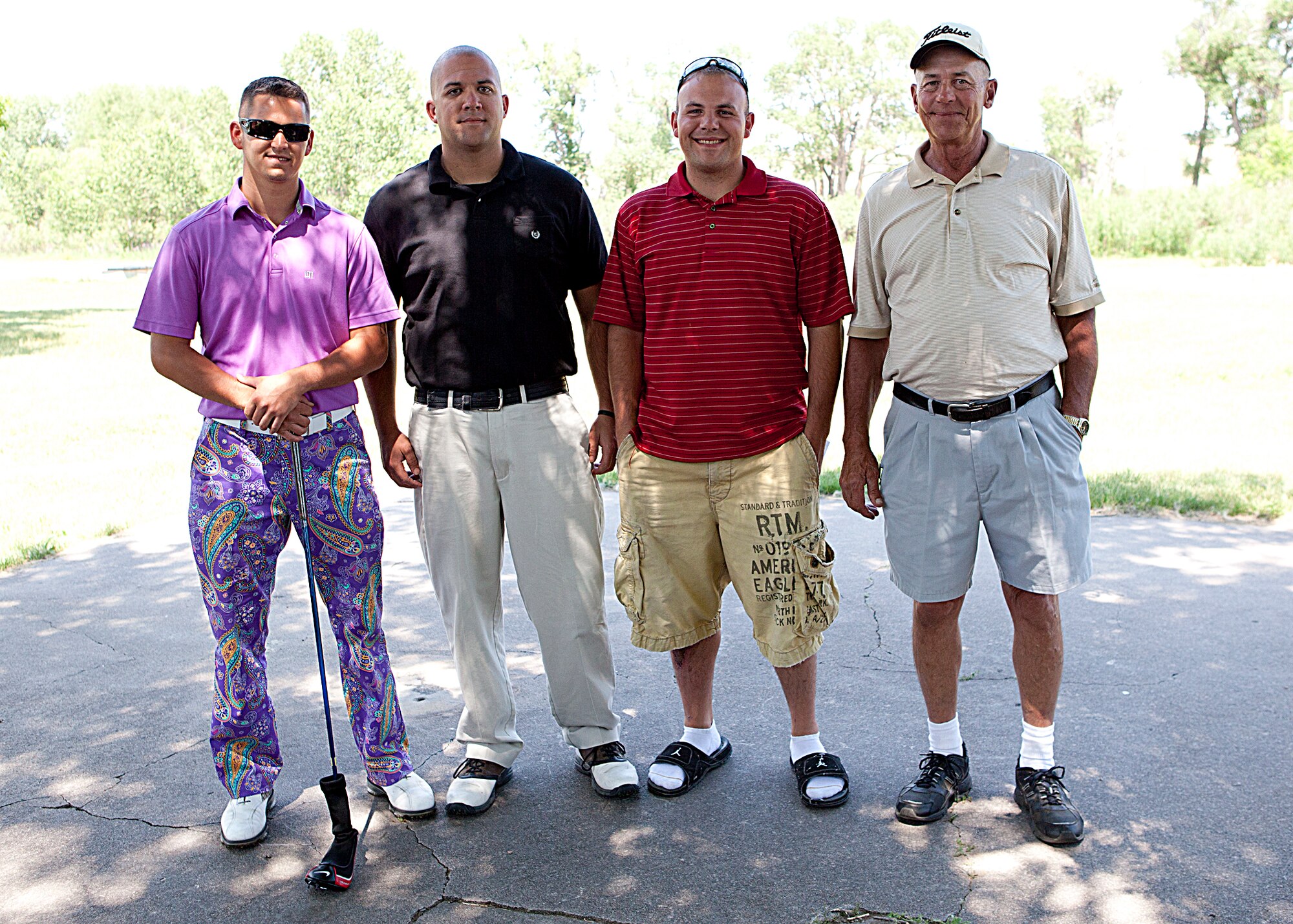 Senior Airman Bryan Gill, SSgt Aaron Withey, SrA Shane Buckholz, and Larry Stockdale pose for a photograph after winning the Global Strike Challenge fundraising golf tournament Thursday, July 12. Their team won with a score of 55, 17 under par. SrA Bryan Gil also won the long drive competition with a long drive of 340 yards. (U.S. Air Force photo by Matt Bilden)