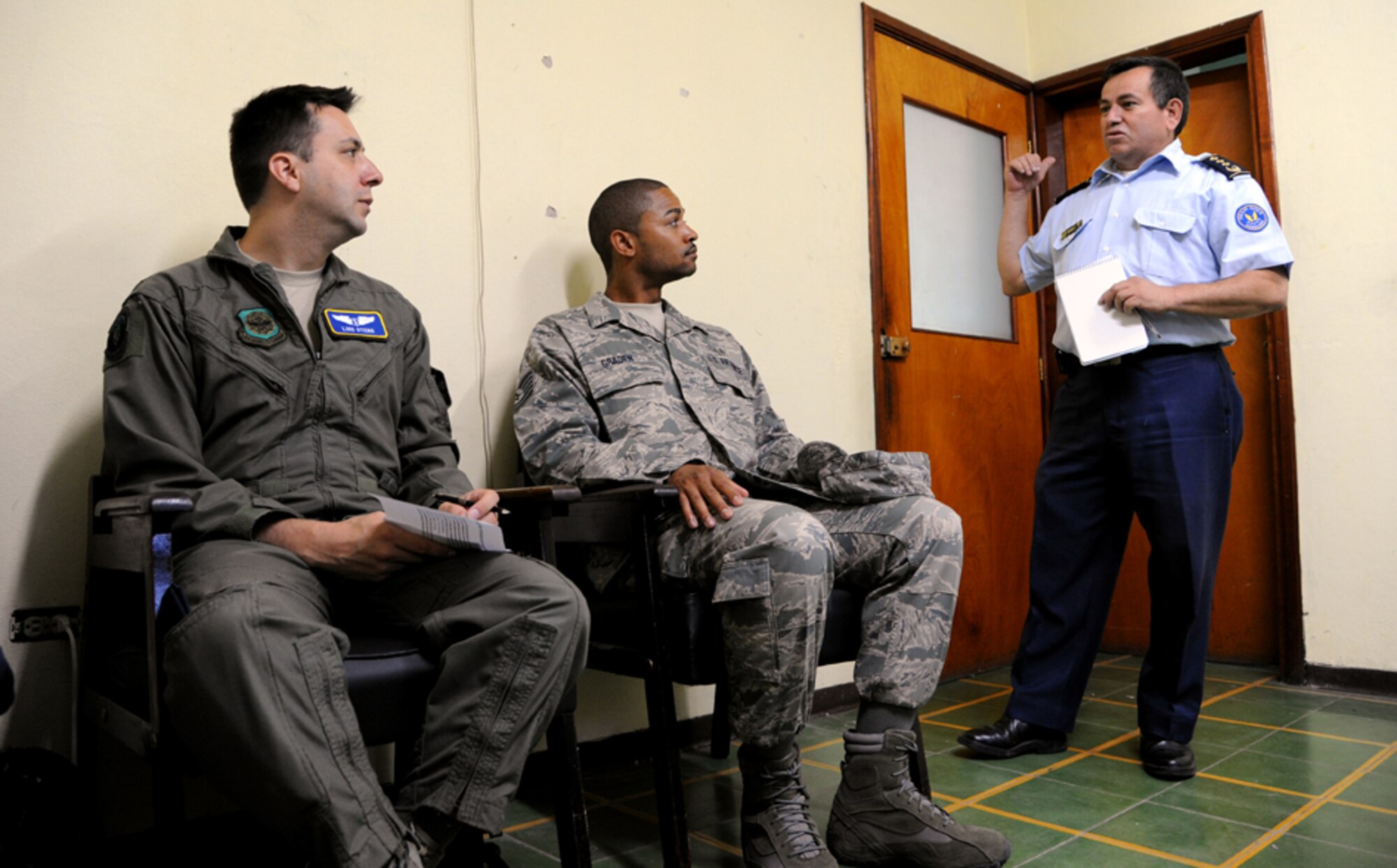Major Luis Otero, a flight surgeon with the 60th Medical Operations Group, and Technical Sergeant Terrence Graden, an Independent Duty Medical Technician with the 571st Mobility Support Advisory Squadron, listen to remarks from Chief Warrant Officer 3 Manuel Evon Lopez, Hernan Acosta Mejia Air Force Base Clinic Administrator, on July 17, 2012 in Tegucigalpa, Honduras.  Over the next 30 days Otero, Graden, and Hernan will continue trading ideas and experiences to help each other as part of efforts to build partner capacity in between the U.S. and Honduran air forces.  (U.S. Air Force photo/Staff Sgt. James Stewart)