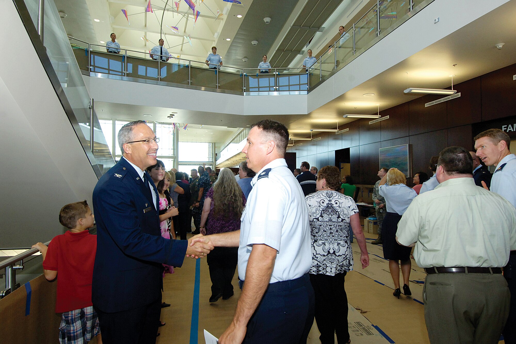 Col. Dean Prentice, 72nd Medical Group commander, left, is all smiles as he welcomes medical group staff and visitors inside the new clinic after the July 16 ribbon cutting ceremony. (Air Force photos by Margo Wright)