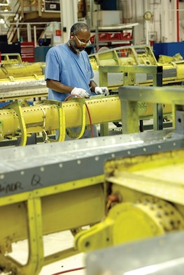 The 551st Commodities Maintenance Squadron Boom Shop handles almost every aspect of overhauling the long refueling booms from initial inspection, working sheet metal and reassembly. Sheet metal mechanic Ron Bagby works in a sea of booms. (U.S. Air Force photo/Margo Wright) 
