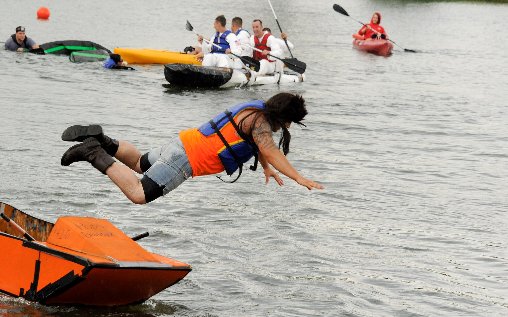 Airman 1st Class John Higgins from the 305th Aerial Port Squadron, 'abandons ship' as the final race of the inaugural Cardboard Boat Regatta July 14 at Willow Pond here. The 305th APS won the fastest time trophy with a time of 1:35 in their orange, hemi powered boat. (U.S. Air Force photo by Airman 1st Class Ryan Throneberry/Released)

