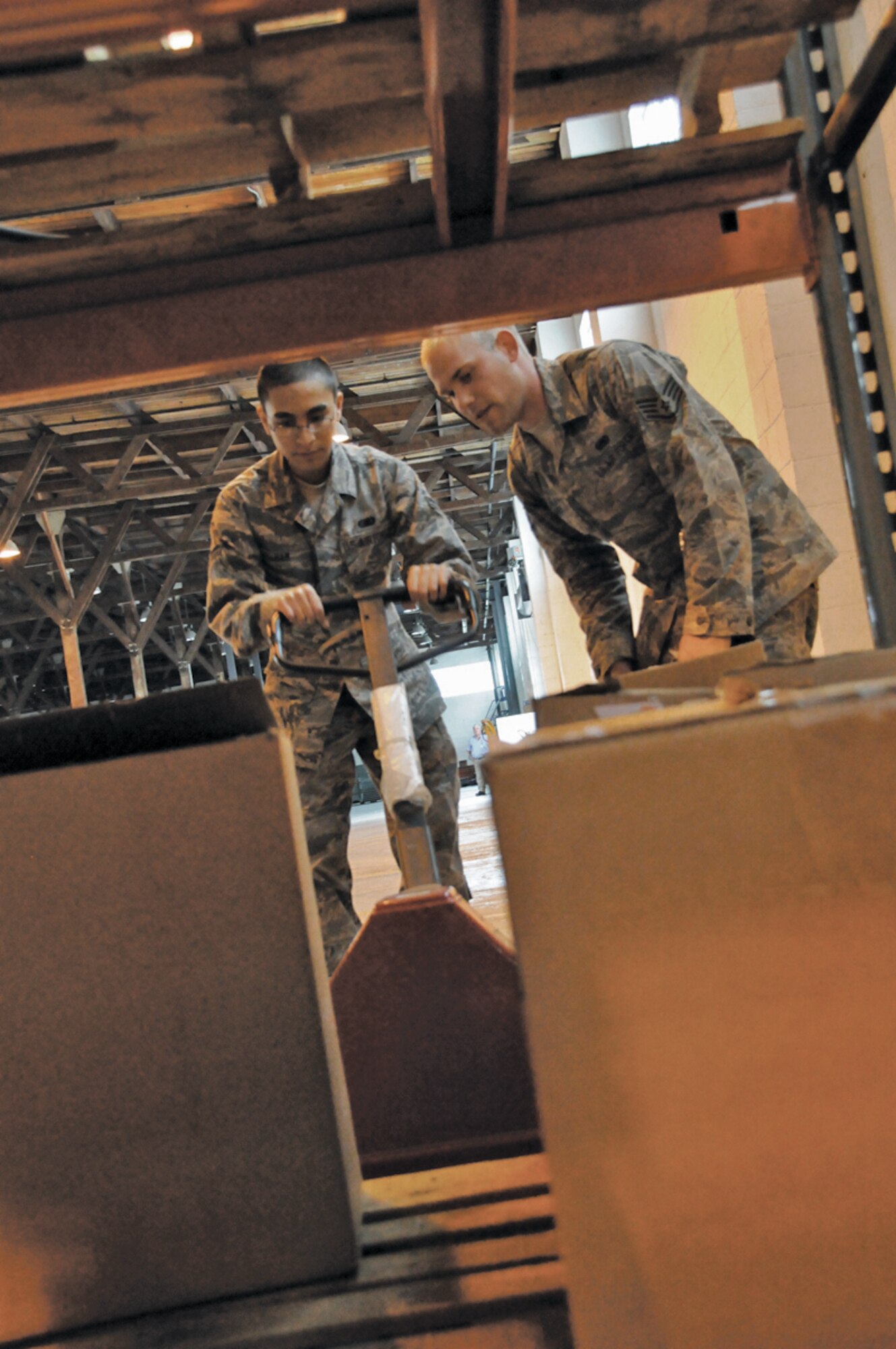 Airman 1st Class Wai Ming Ham, 439th Logistics Readiness Squadron, learns how to properly use a pallet jack at the supply warehouse from Staff Sgt. John Barnets, 65th LRS. Ham, who is approximately six months new to the Air Force and two months new to his Reserve unit, is here with other Airmen from the 439th LRS to receive two weeks of hands-on careerfield skills training from their 65th LRS active duty counterparts. (U.S. Air Force photo by Staff Sgt. Angelique Smythe) 