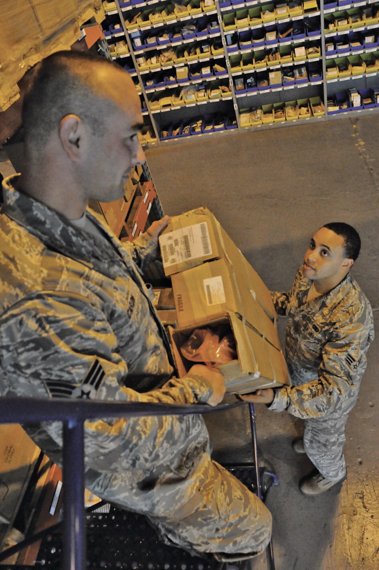 Senior Airman James Carson, 439th LRS, works with Senior Airman Doctavius French in the supply warehouse. Carson, who is also a stone mason and a student studying fire science, deployed to Lajes with his Reserve unit to perform on-the-job training for two weeks. (U.S. Air Force photo by Staff Sgt. Angelique Smythe)