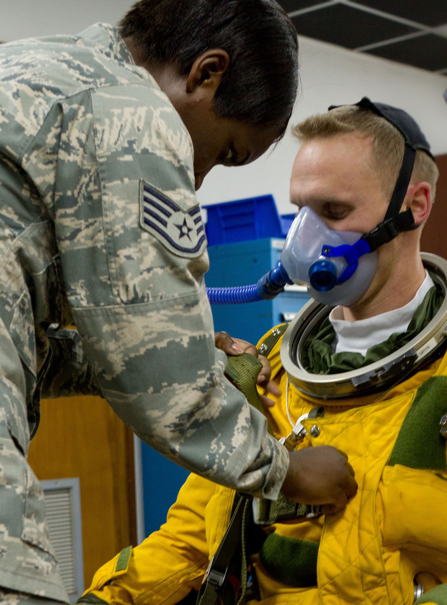 SOUTHWEST ASIA - U.S. Air Force Staff Sgt. Jasmine Chambers, 99th Expeditionary Reconnaissance Squadron physiology support detachment technician, helps Capt. Peter, 99th ERS U-2 pilot, into a full-pressure suit July 17, 2012. Two PSD technicians and a supervisor are required to assist the pilot into the suit to prevent damage. (U.S. Air Force photo/Senior Airman Alexander Recupero)