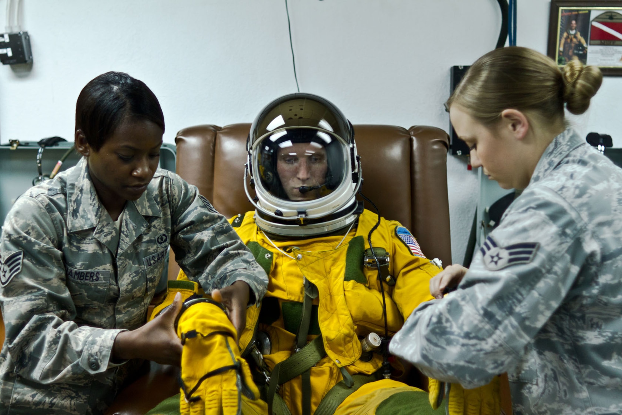 SOUTHWEST ASIA - U.S. Air Force Staff Sgt. Jasmine Chambers and Senior Airman Cortney Reeb, 99th Expeditionary Reconnaissance Squadron physiology support detachment technicians, help Capt. Peter, 99th ERS U-2 pilot, into a full-pressure suit before testing its integrity July 17, 2012. The U-2 routinely flies at altitudes in excess of 70,000 feet, which requires the pilot to wear the suit. (U.S. Air Force photo/Senior Airman Alexander Recupero)