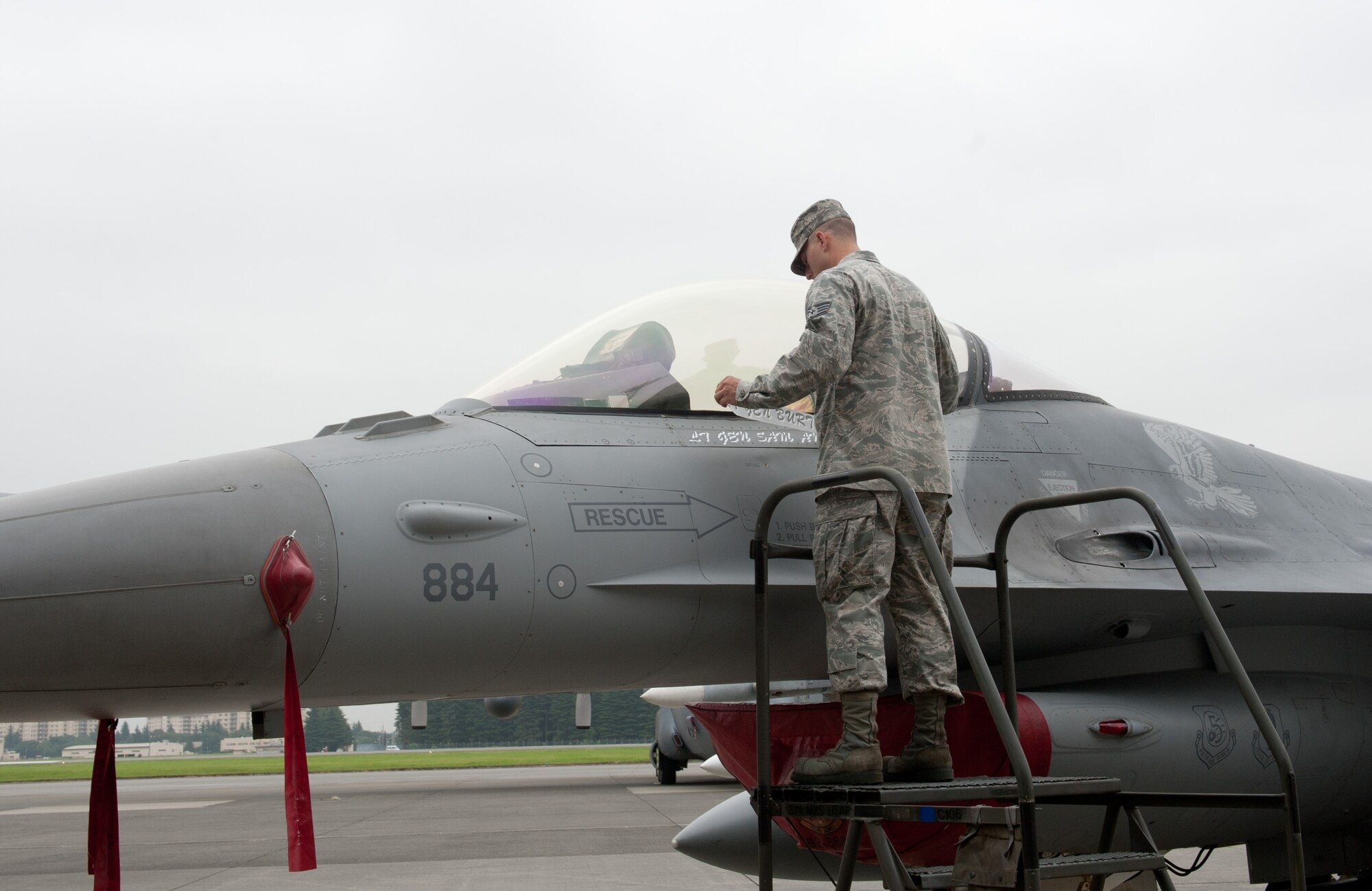 Staff Sgt. Sean Rindfleish, 13th Aircraft Maintenance Unit dedicated crew chief, reveals the name of the new U.S. Forces, Japan, and 5th Air Force commander, Lt. Gen. Sam Angelella, on the 5th AF F-16 Fighting Falcon aircraft during a change of command ceremony here July 20, 2012. (U.S. Air Force photo by Senior Airman Salazar)