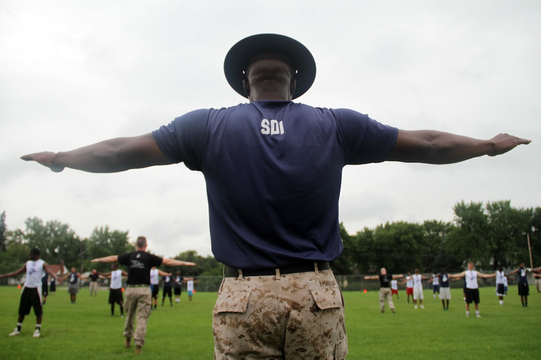 Marines with Recruiting Substation Coon Rapids and senior drill instructor Gunnery Sgt. Winford Morris, 34, from Meridian, Miss., lead the Minneapolis Diamond Flight Camp in a dynamic warm-up exercise on July 21.