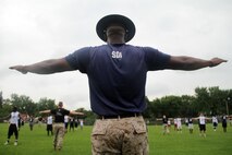 Marines with Recruiting Substation Coon Rapids and senior drill instructor Gunnery Sgt. Winford Morris, 34, from Meridian, Miss., lead the Minneapolis Diamond Flight Camp in a dynamic warm-up exercise on July 21.