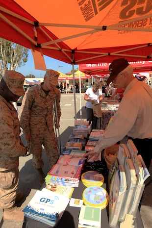 Marines look at information provided by Marine and Family Programs displayed at the 13th annual San Onofre Community Center Community Day Celebration, July 21. Booths set-up around the parking lot offered crafts, giveaways and resources about that organization located on base or in the surrounding community.