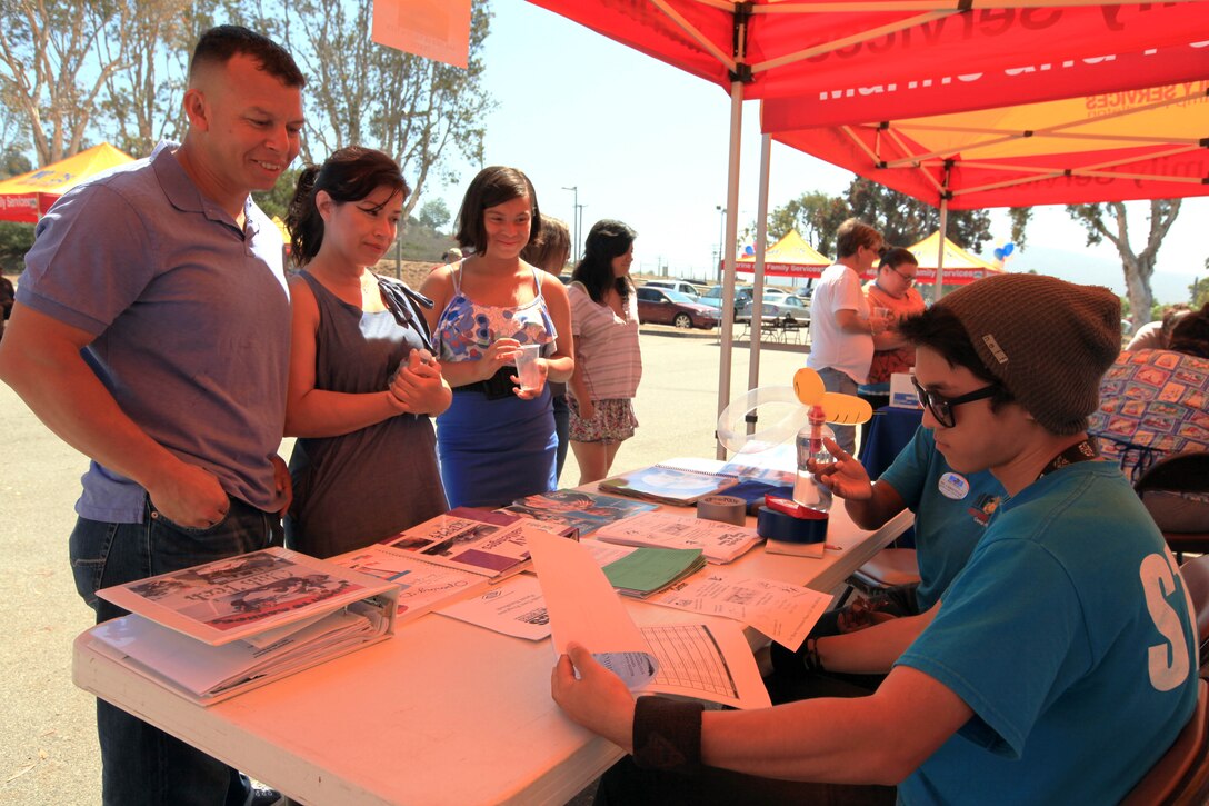 A family attending the 13th annual Community Day Celebration looks at information about youth programs at the San Onofre Community Center, July 21. The Community Day Celebration is held to give service members and their families information about the surrounding community.