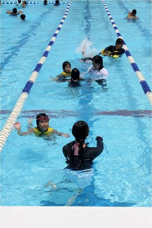 Children from Yahata Gakuen children's home play with Marines and station communtiy-relations volunteers in the WaterWorks pool during the pool party hosted by Marine Wing Support Squadron 171 here July 21, 2012. The children experienced a day of fun with a volunteer Marine or sailor buddy.