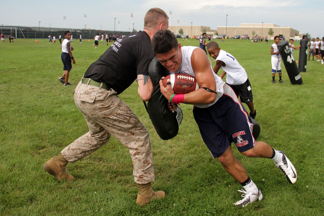 Recruiting Substation Coon Rapid's Sgt. Matt Talbot, 27, from Duluth, Minn., bumps Anastacio VandenBosch-Romo during a linebacker exercise at Junior Rank's Minneapolis Diamond Flight Camp on July 22. Anastacio, a 16-year-old sophomore at Henry Sibley High School, was one of two athletes who received the camp's Excellence in Leadership Award. For additional imagery from the event, visit www.facebook.com/rstwincities.