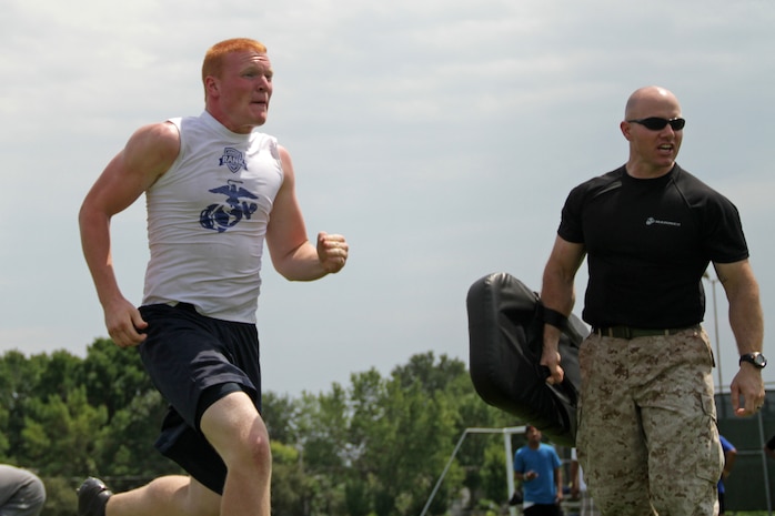 Mac Hamlin runs past Gunnery Sgt. Eric McIntosh during an obstacle course at the Minneapolis Diamond Flight Camp July 22. Coaches selected him as the most-improved player at the camp. Hamlin, a 17-year-old senior at Hudson High School, is currently in Recruiting Substation Woodbury's Delayed Entry Program.