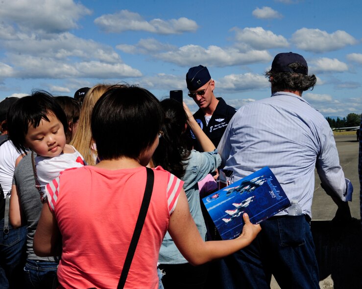 Capt. Michael Fisher, U.S. Air Force Thunderbirds pilot, signs autographs after performing a flying demonstration July 21, 2012, during the 2012 Joint Base Lewis-McChord Air Expo at McChord Field, Wash. (U.S. Air Force photo/Staff Sgt. Frances Kriss)