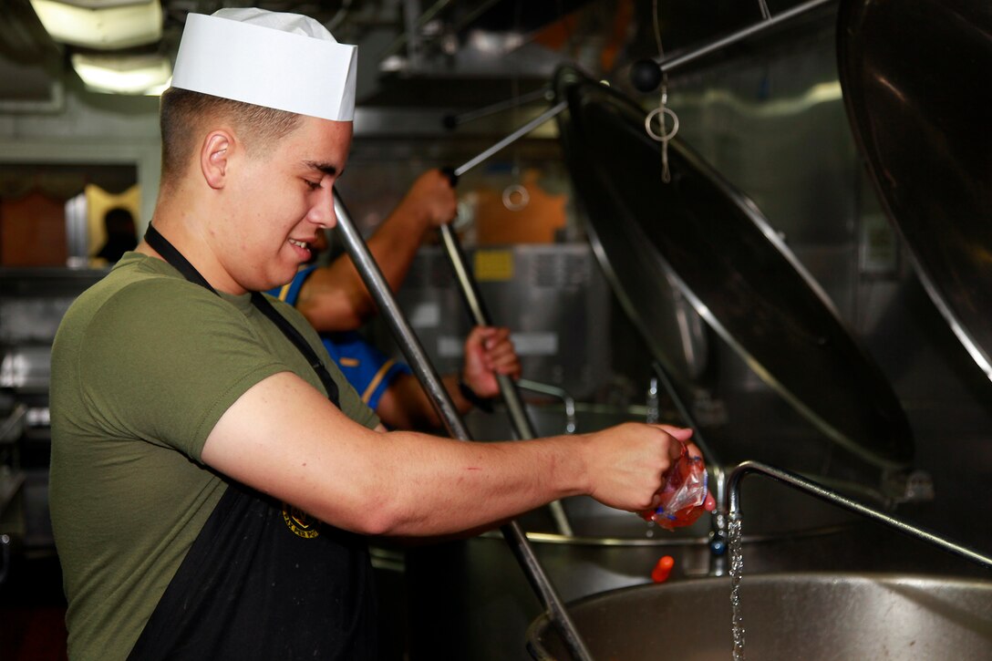 Lance Cpl. Christopher L. Gonzales, food service specialist, Marine Medium Helicopter Squadron 364, helps prepare lunch in the ship’s galley, July 22. Gonzales, 20, is from Fresno, Calif., is one of the Marine food service specialists and helps prepare lunch and dinner for the Marines and sailors of the 15th Marine Expeditionary Unit and Peleliu Amphibious Ready Group.