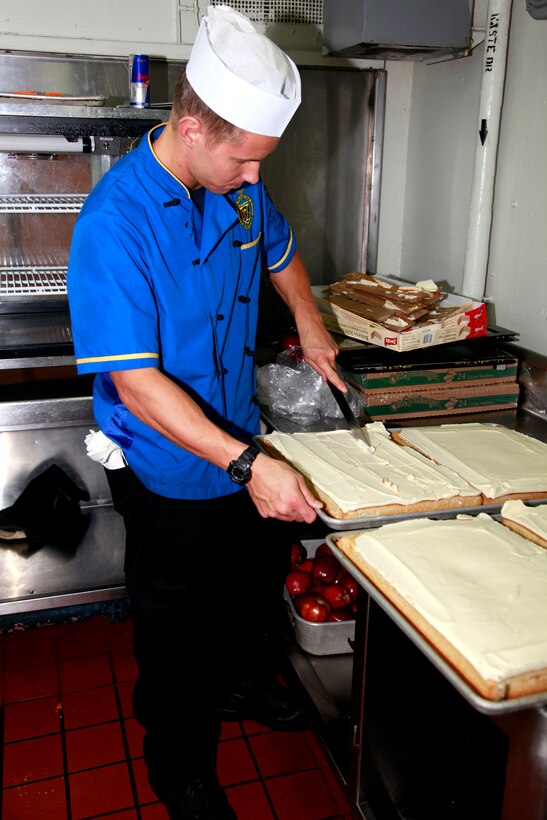 Petty Officer 3rd Class John A. Estes, culinary specialist, USS Peleliu, prepares desserts in the ship’s galley for the Marines and sailors of the 15th Marine Expeditionary Unit and Peleliu Amphibious Ready Group, July 22. Estes, 21, is from Alexandria, Minn.