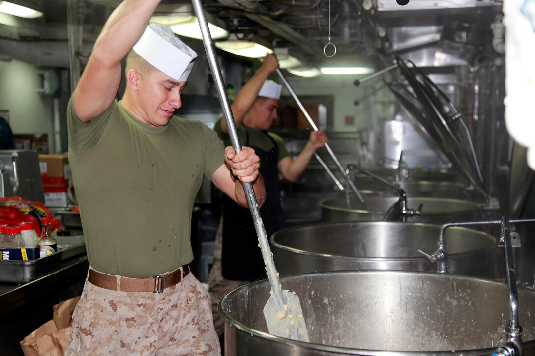 Sergeant Refugio Gil, food service specialist, Marine Medium Helicopter Squadron 364, 15th Marine Expeditionary Unit, helps prepare lunch in the ship’s galley, July 22. Gil, 28, is from Nipomo, Calif., and supervises the food service specialists and messmen who work on the troop mess deck to prepare lunch and dinner for the Marines and sailors of the 15th Marine Expeditionary Unit and Peleliu Amphibious Ready Group.
