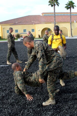Sgt. Kyle A. Ford, drill instructor, Company F, 2nd Recruit Training Battalion, orders recruits to execute the tan belt leg sweep technique aboard Marine Corps Recruit Depot San Diego July 18. Recruits were tested on all techniques associated with tan belt Marine Corps Martial Arts. Recruits earned their tan belts only after proving to their drill instructors they could properly execute all tan belt moves. 
