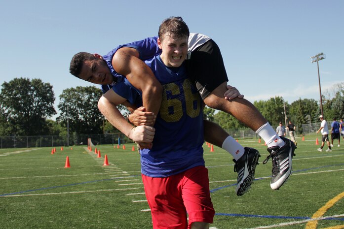 Academy of Holy Angels football player Joey Hurley carries teammate Mikias Alipate during the maneuver-under-fire portion of a modified combat fitness test on July 23. More than 65 athletes completed the event, which was monitored by Marines with Recruiting Substation Bloomington.