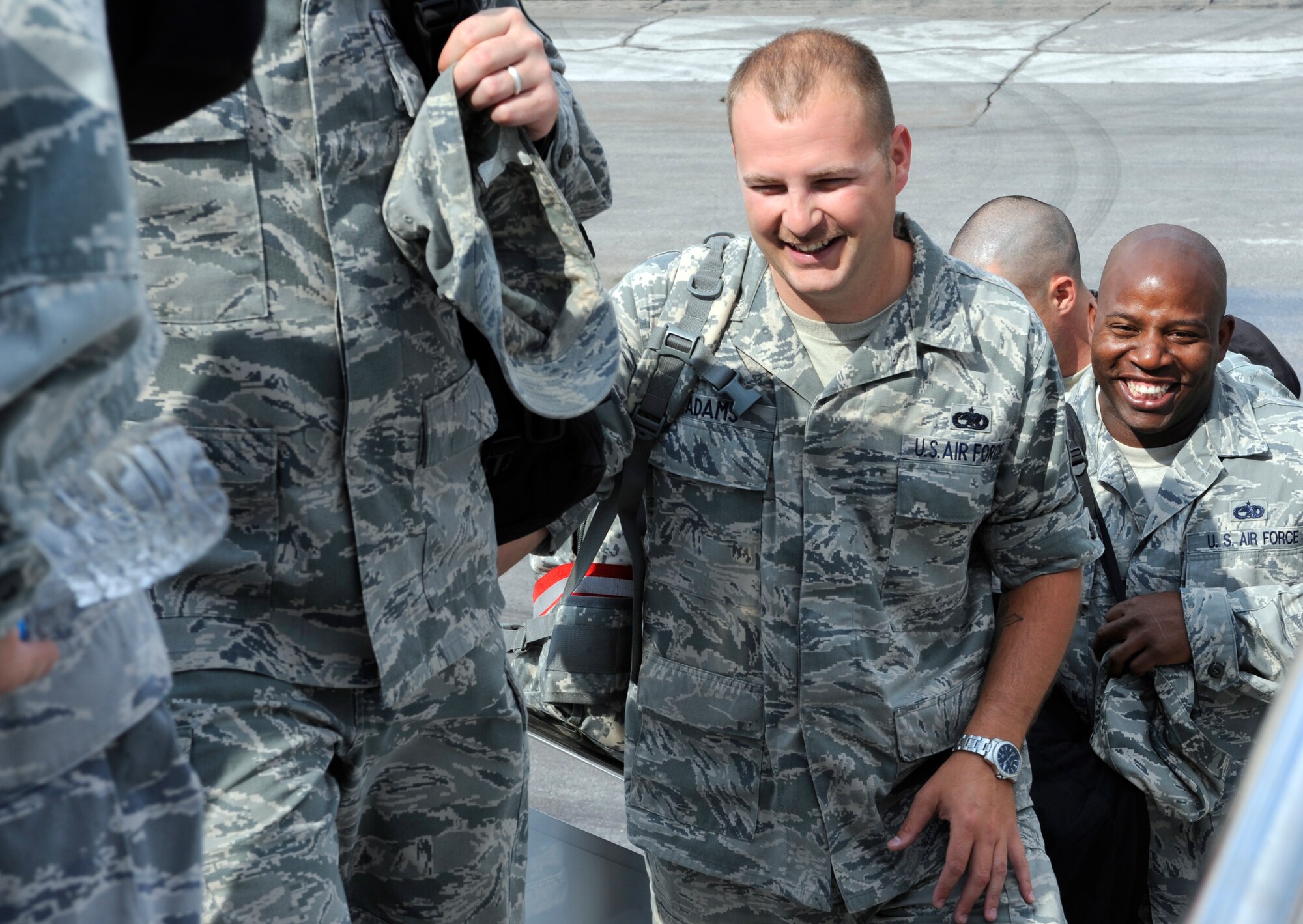 Two Ellsworth Airmen share a laugh prior to boarding a plane on the flightline at Ellsworth Air Force Base, S.D., July 21, 2012. Approximately 350 Airmen deployed to Southwest Asia July 21 to support missions in the U.S. Central Command area of responsibility. (U.S. Air Force photo by Airman Ashley J. Cass/Released)