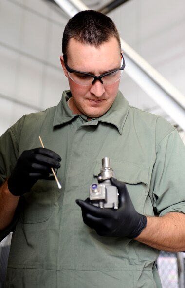 Airman 1st Class Aaron Barber, 28th Maintenance Squadron aerospace propulsion technician, cleans the base of a B-1 engine thermometer with denatured alcohol in an aircraft hangar on Ellsworth Air Force Base, S.D., July 19, 2012. Each engine is equipped with a thermometer that monitors the temperature inside the engine and relays information to the computer system in the cockpit. (U.S. Air Force photo by Airman Ashley J. Cass/Released)