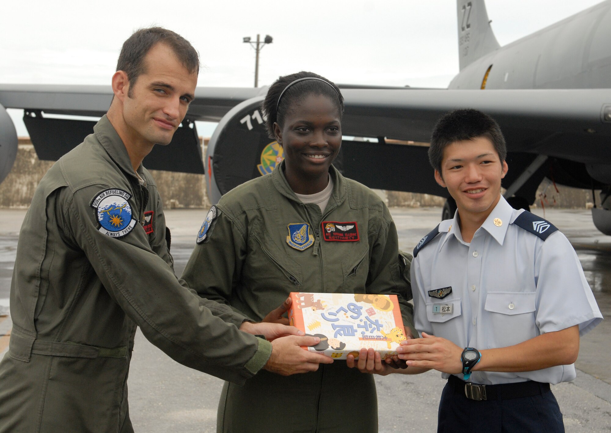 (Left) Staff Sgt. Brian Porter and (right) Airman 1st Class Tiffanie Ellerbe, 909th Air Refueling Squadron in-flight refueler and a ground scheduler for boom operators, accepts a gift from Japan Air Self Defense Force cadets from the Air Force Officer School in Nara Prefecture during a tour on Kadena Air Base, Japan, July 19, 2012. The cadets were appreciative that Airmen from the 909th ARS took time out of their day to show them the aircraft. (U.S. Air Force photo/Airman 1st Class Malia Jenkins) 