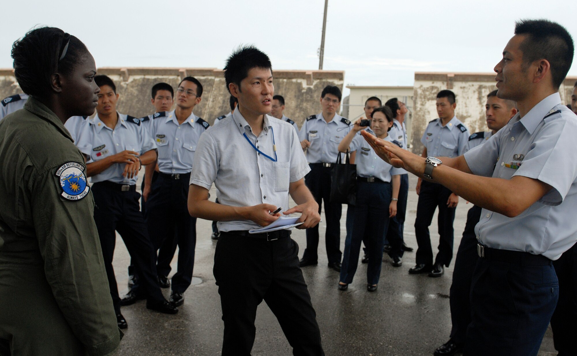 Airman 1st Class Tiffanie Ellerbe, 909th Air Refueling Squadron ground scheduler for boom operators, answers a question from Japan Air Self Defense Force's Air Officer Candidate School instructor in Nara Prefecture during a tour on Kadena Air Base, Japan, July 19, 2012. Approximately 120 cadets had the chance to interact with Airmen and learn about the 18th Wing's mission and its capabilities. (U.S. Air Force photo/Airman 1st Class Malia Jenkins)   