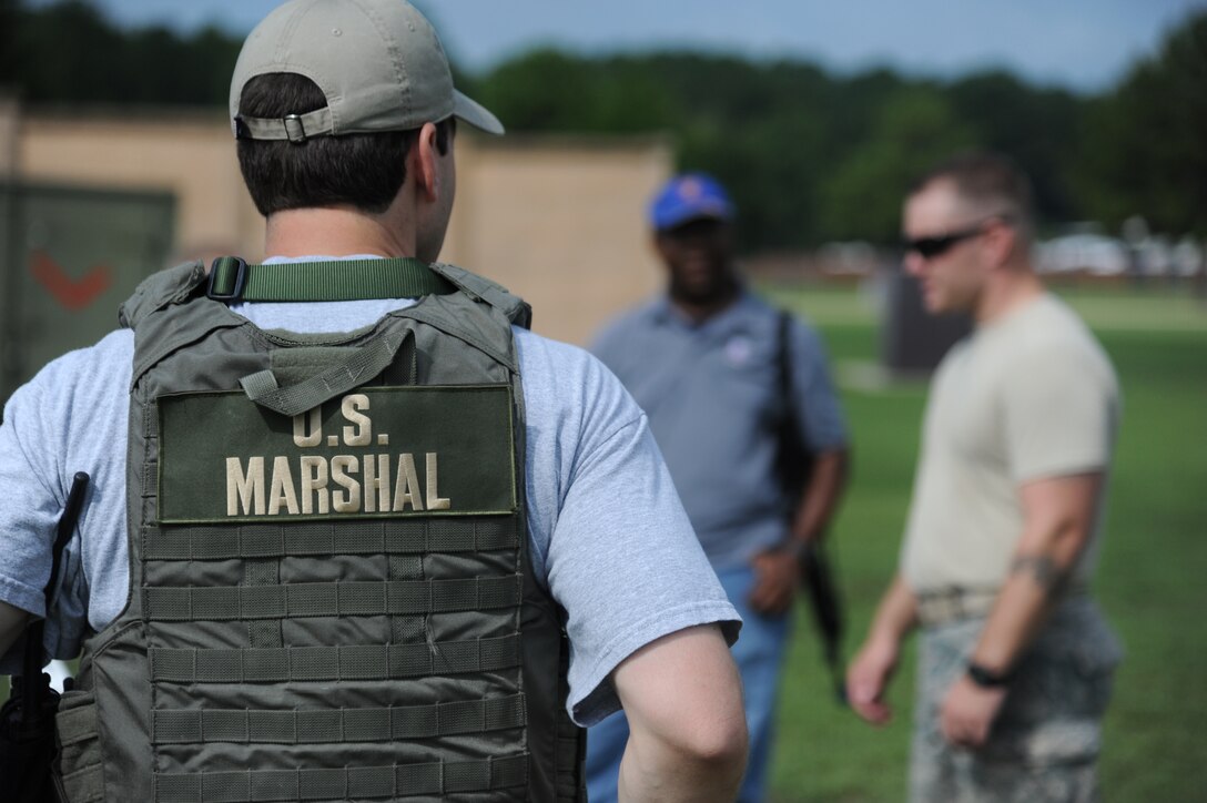 Deputy United States Marshals listen to Senior Airman Jason Ashmore, 14th Security Forces Squadron at Columbus Air Force Base July 19 as he explains the exercises that they will be participating in.  The Marshals engaged in multiple exercises including a force on force exercise with multiple scenarios, a Shoot Move Communicate course and use of a Fire Arms Training Simulator.  (U.S. Air Force Photo/Airman 1st Class Charles Dickens)