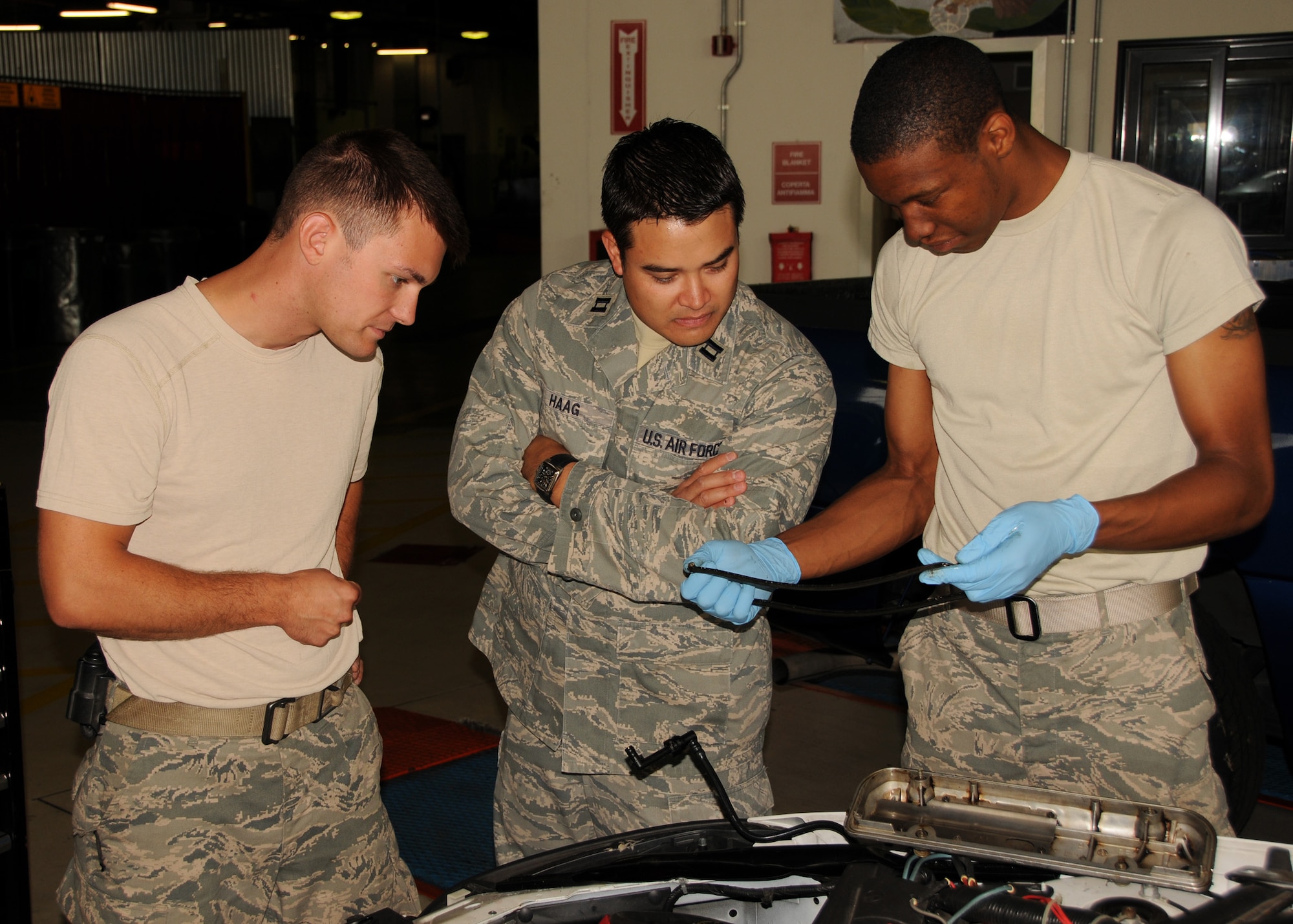 Airman first class Quinn Parham, 31st Logistics Readiness Squadron vehicle mechanic, examins a gasket while Captain Michael Haag, 944 Logistics Readiness Squadron, and Senior Airman Vlad Mirochnitchencko, 944th Logistics Readiness Squadron vehicle mechanic, observe.  (U.S. Air Force photo by Staff Sgt. Louis Vega Jr.)