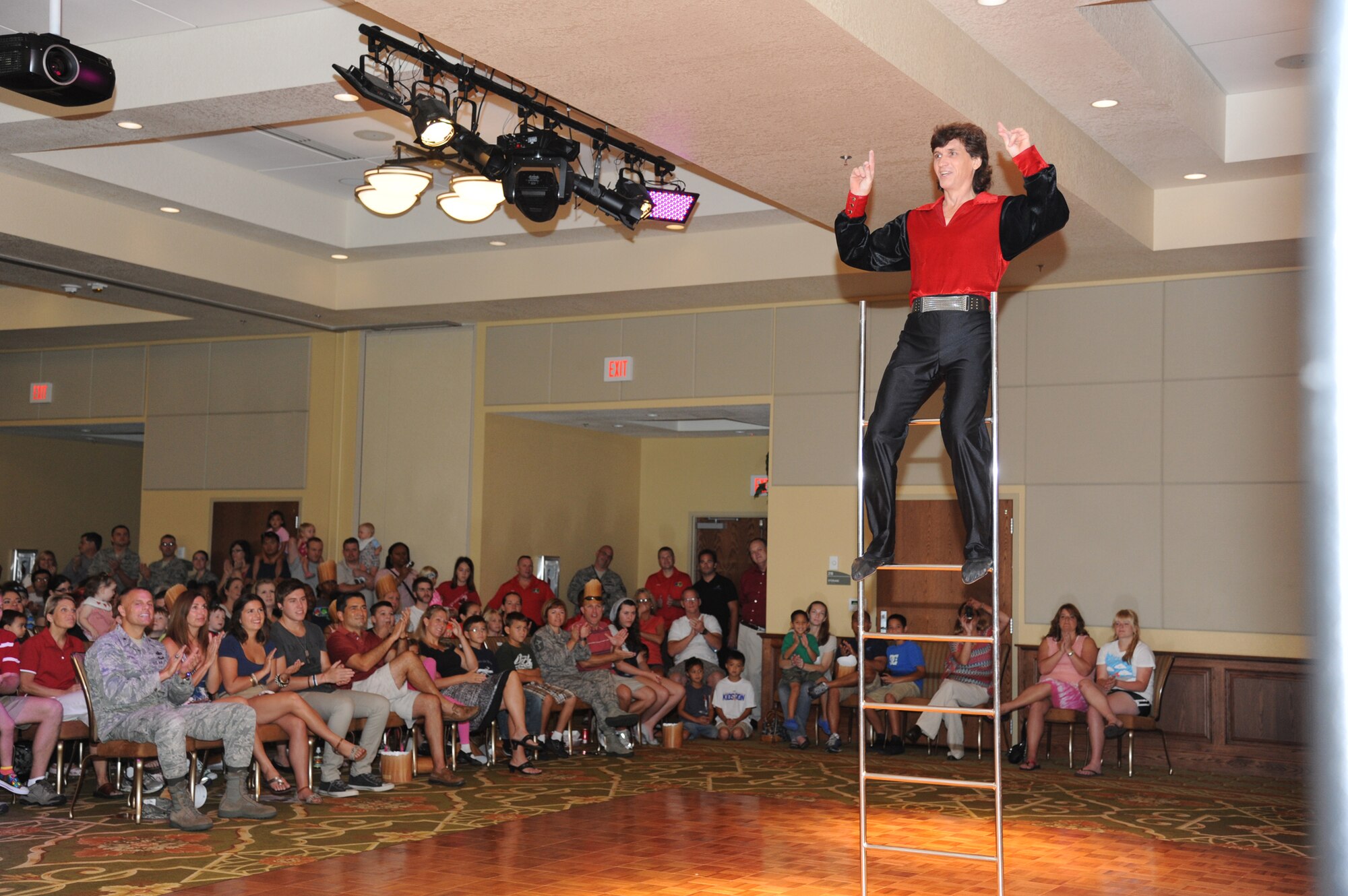 Alexander Ribkovets, a member of Fata Morgana, performs a balancing act using a ladder during a military appreciation show for Keesler families July 21, 2012, at the Bay Breeze Event Center, Keesler Air Force Base, Miss.  Fata Morgana, an Italian phrase meaning optical illusion, featured a small number of various acts throughout the show.  (U.S. Air Force photo by Kemberly Groue)
