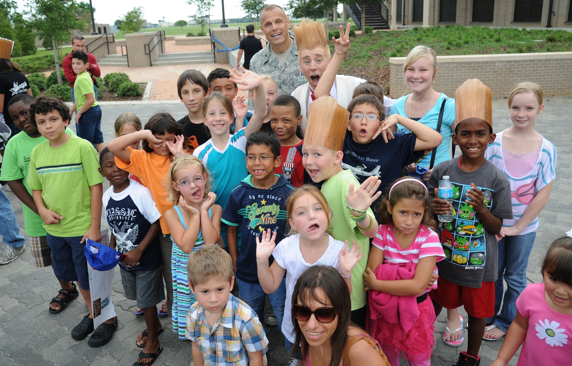 Brig. General Brad Spacy, 81st Training Wing commander, and Keesler Air Force Base children pose for a photo with Bello Nock, comedic daredevil and international circus star for Fata Morgana, following a military appreciation show for Keesler families July 21, 2012, at the Bay Breeze Event Center, Keesler Air Force Base, Miss.  Fata Morgana, an Italian phrase meaning optical illusion, featured a small number of various acts throughout the show.  (U.S. Air Force photo by Kemberly Groue)