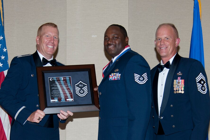 U.S. Air Force Tech Sgt. Melvin Spriggs, 23d Maintenance Operations Squadron, accepts his certificate of induction Col. Steven Ramer, 23d Wing vice commander, and Chief Master Sgt. Frank Batten, 23d Wing command chief, during a SNCO induction ceremony July 20, 2012, at Moody Air Force Base, Ga. Spriggs is one of 100 Moody inductees to put on the rank of master sergeant this cycle. (Airman 1st Class Paul Francis/Released) 