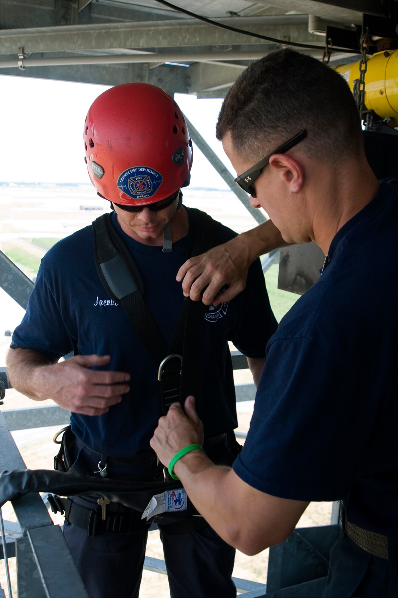 GRISSOM AIR RESERVE BASE, Ind. -- Thomas Carey, Grissom firefighter, helps secure a harness to fellow firefighter Robert Jacobs before he rappels down the base radar tower July 11. The Grissom Fire Department tested new harnesses used for rescue operations. (U.S. Air Force photo/Senior Airman Andrew McLaughlin)