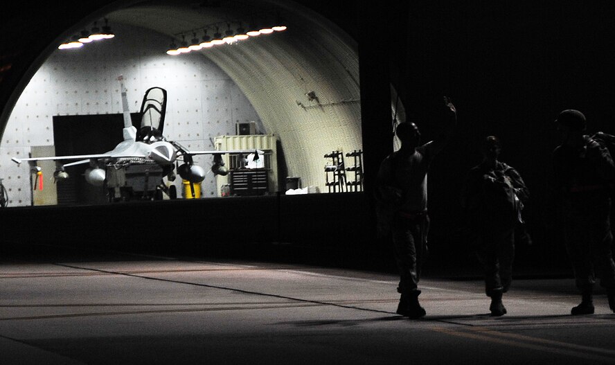 Airmen walk along the flightline during the start of exercise Beverly Midnight 12-03, July 23, 2012. The week-long exercise tests Osan’s ability to operate in a heightened state of readiness. This is the third readiness exercise for Team Osan in 2012. (U.S. Air Force photo/Staff Sgt. Stefanie Torres)