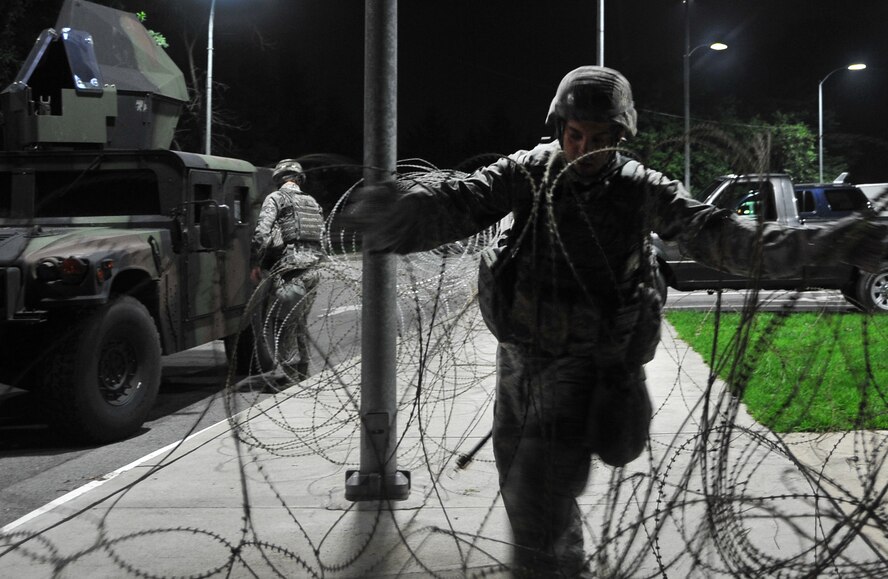 Tech. Sgt. Michael Pistolich sets up concertina wire near the 51st Fighter Wing headquarters building, July 22, 2012. Airmen are participating in Beverly Midnight 12-03, a readiness exercise that tests Team Osan’s ability to defend the base and conduct daily operations during a heightened state of readiness. Pistolich is a 51st Security Forces Squadron member. (U.S. Air Force photo/Staff Sgt. Stefanie Torres)