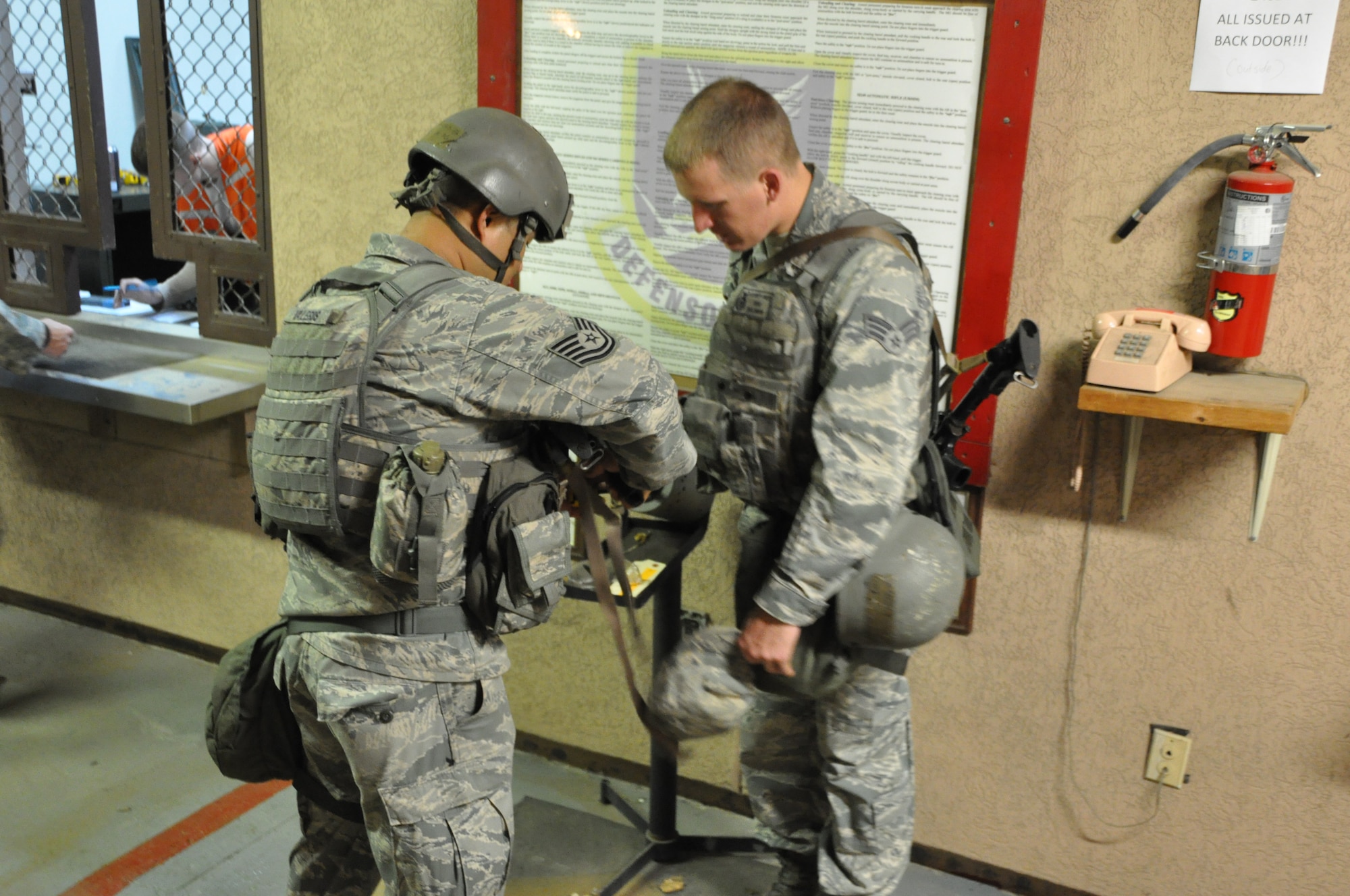 Osan Air Base's 51st Security Forces Squadron Airmen and base augmentees receive weapons from the armory July 22, 2012. Airmen reported following an exercise recall to report in a heightened state of readiness. Airmen here are participating in Beverly Midnight 12-03, the third operational readiness exercise in 2012. (U.S. Air Force photo/Airman 1st Class Alexis Siekert)