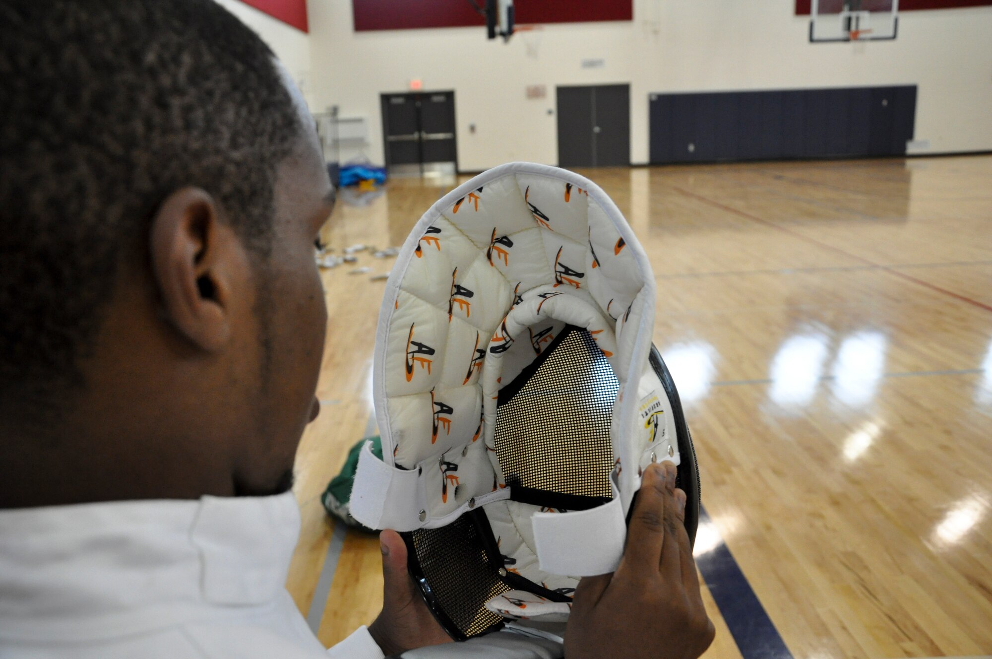 BUCKLEY AIR FORCE BASE, Colo. -- Alex Vasquez prepares to put on a fencing helmet at the Buckley Youth Center July 18, 2012.  The youth center held activities all week as part of their Youth Sports Sideline Camp.  (U.S. Air Force photo by Staff Sgt. Nicholas Rau)  