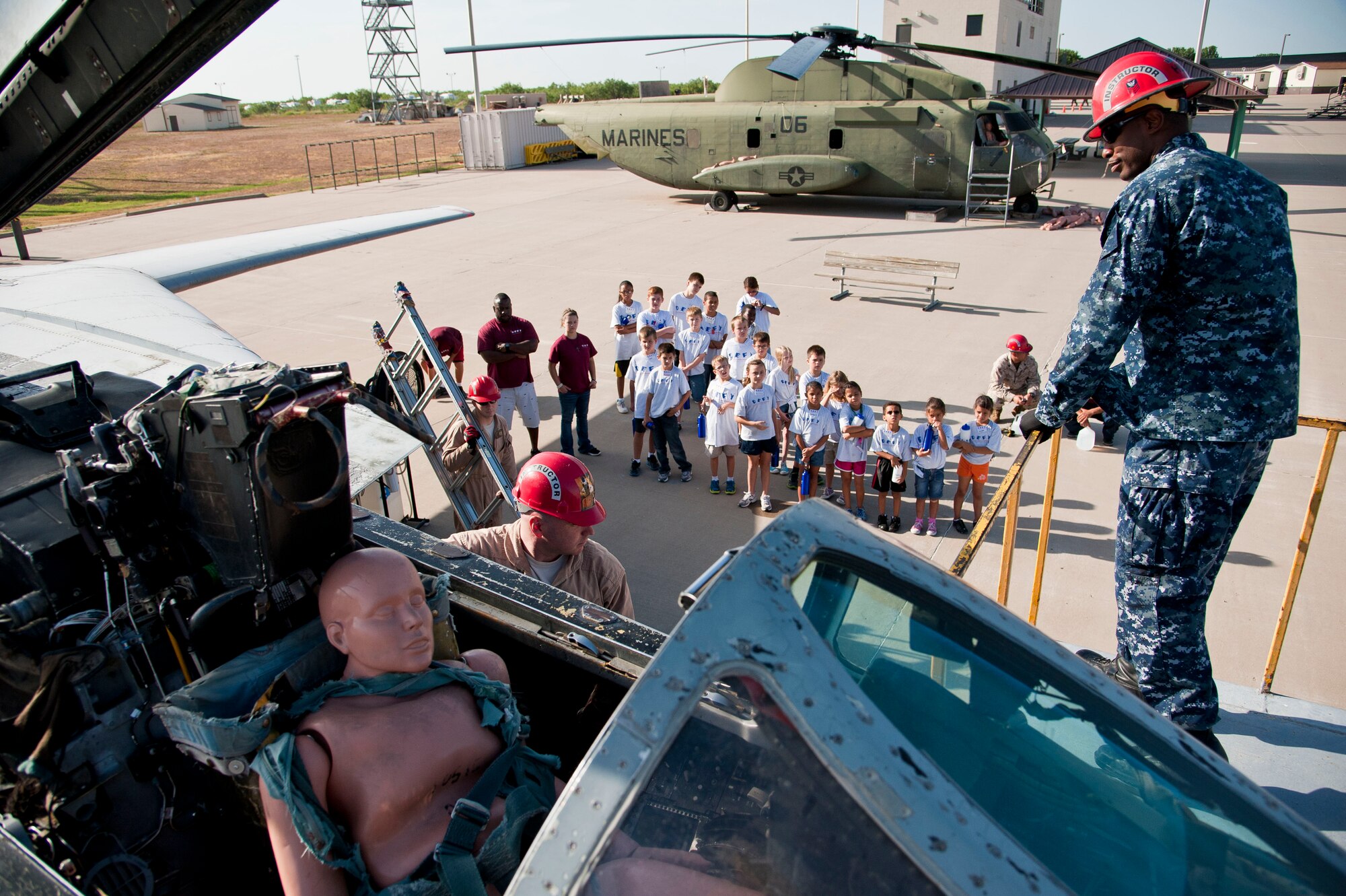 GOODFELLOW AIR FORCE BASE, Texas-- Petty Officer 1st Class Jerell Hurdle, 312th Training Squadron instructor, talks the Drug Education for Youth Camp children through rescuing an aircraft pilot at Louis F. Garland DOD Fire Academy July 17. The DEFY camp helps teach children the potential dangers of drugs and ways they can affect your life. (U.S. Air Force photo/Airman 1st Class Michael Smith) 