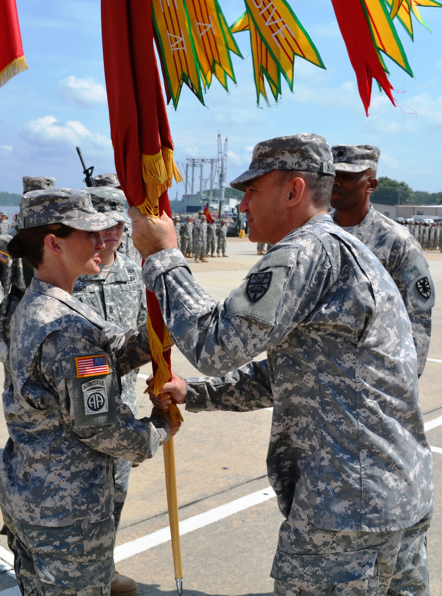 U. S. Army Col. Lawrence Kominiak, 7th Sustainment Brigade commander, right, passes the 10th Transportation Battalion colors to the new commanding officer, Lt. Col. Megan Gumpf, left, during a change-of-command and change-of-responsibility ceremony at 3rd Port on Fort Eustis, July 20, 2012. The ‘Waterborne’ battalion bid farewell to Lt. Col. Kenneth Williams and 1st Sgt. Compton Johnson, the 10th Trans. Bn. commander and command sergeant major, respectively.  (U.S. Army photo by Staff Sgt. Alexander Burnett/Released)