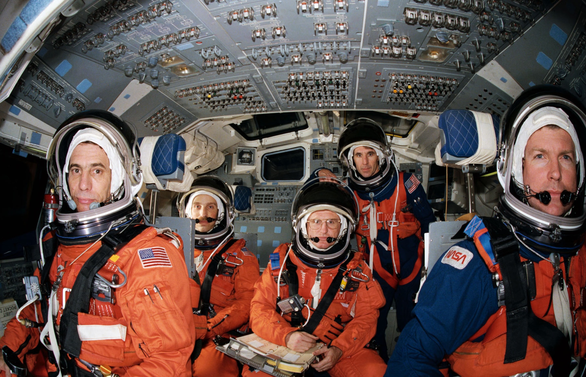 STS-29 crewmembers, wearing launch and entry suits, participate in exercises in the Crew Compartment Trainer (CCT) in February 1989. Four crewmembers are pictured in the stations they will man for entry phase of the mission. They are joined by the fifth crewmember, "borrowed" from the mid deck. At forward controls are Pilot John E. Blaha (left) and Commander Michael L. Coats. Behind them are Mission Specialists James P. Bagian (left) and James F. Buchli. Mission Specialist Robert C. Springer stands at aft station. Springer will occupy Discovery's mid deck for entry phase of the flight while Bagian will occupy that post for launch. (NASA photo by Bill Bowers)