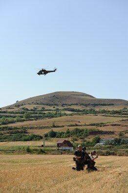 A Romanian IAR 330 helicopter flies above as Capt. Maureen Hartney, 81st Fighter Squadron executive officer, is rescued by Romanian air force special forces members during a combat search and rescue training exercise in a field here July 19, 2012. This CSAR exercise was a part of Dacian Thunder, a month-long partnership building exercise in which U.S. Air Force, Romanian air force, U.S. Marine Corps and the Royal Air Force exchange techniques, tactics, and procedures to strengthen coalition and joint capabilities. (U.S. Air Force photo by Senior Airman Natasha Stannard)
