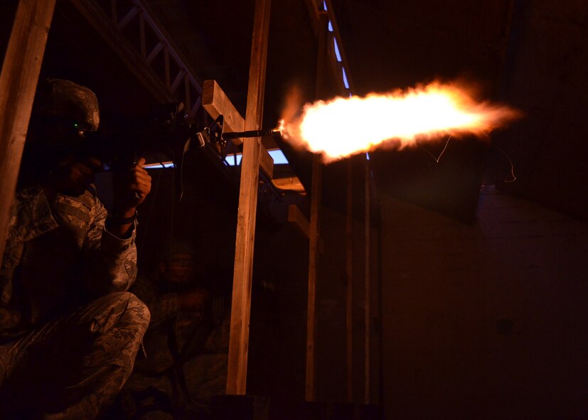Senior Airman Alexi Patterson, 7th Security Forces Squadron fires an M-4 Carbine during night-fire training July 19, 2012 at Dyess Air Force Base, Texas. Airmen fired 70 rounds from an M-4 Carbine mounted with a PVS-14 in front of a red dot sight. The scope collects small amounts of light and amplifies it, allowing the shooter to see down range in low-light situations. The targets were 25 feet away, but distances are simulated between 70 and 300 meters. (U.S. Air Force photo by Airman 1st Class Damon Kasberg/Released)